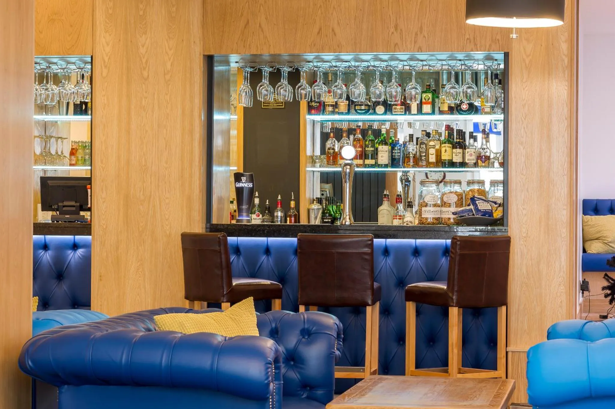 Un comptoir de bar moderne avec des tabourets et un canapé bleu.