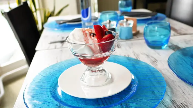 Une table est dressée avec un dessert aux fruits frais.