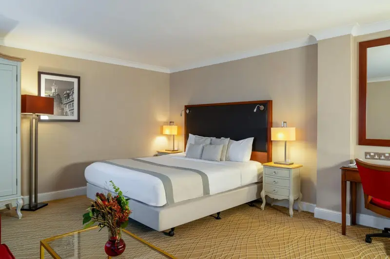 Une chambre lumineuse avec un grand lit et une décoration sobre.