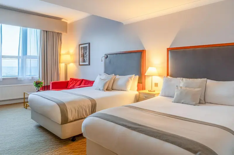 Une chambre d'hôtel lumineuse avec deux lits et une décoration moderne.
