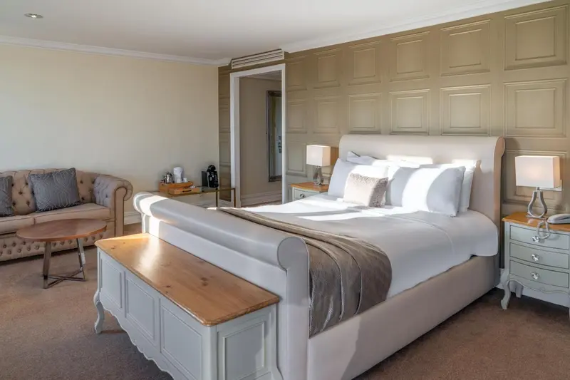 Une chambre lumineuse avec un grand lit et un canapé.