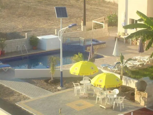 Terrasse avec parasols et piscine rectangulaire.