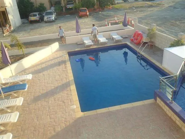 Une piscine rectangulaire avec des transats et des parasols.