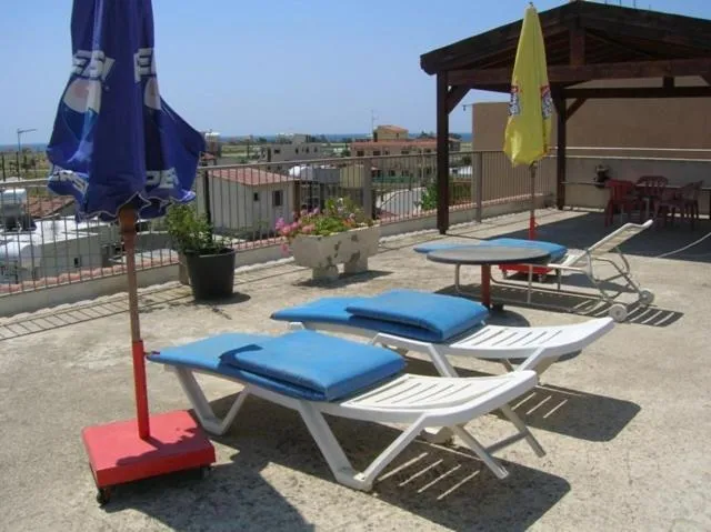 Terrasse avec transats et parasols offrant une vue sur le paysage.