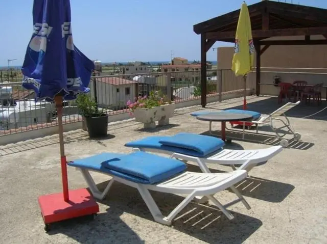 Terrasse avec transats et parasols offrant une vue sur le paysage.
