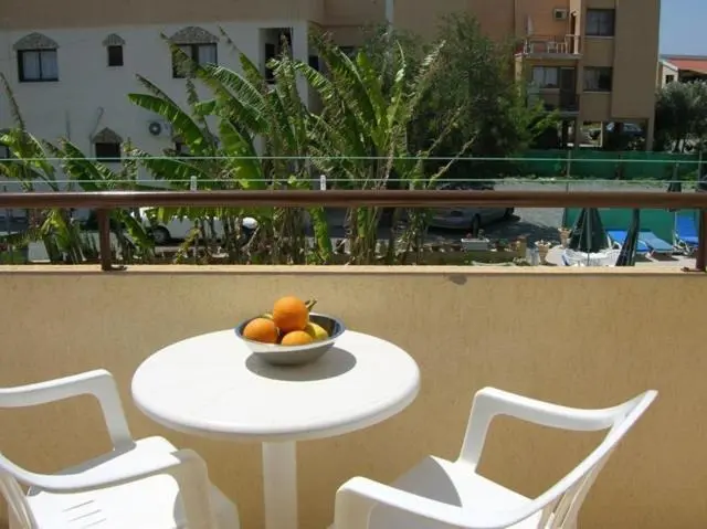 Une table ronde avec des fruits est mise en scène sur un balcon.