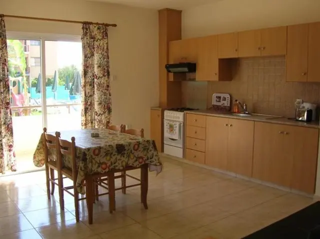 Une cuisine lumineuse s'ouvre sur une table à manger près d'une baie vitrée.