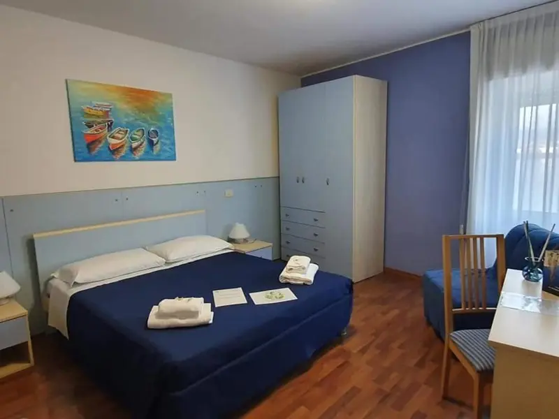 Une chambre lumineuse avec un grand lit et un coin salon.