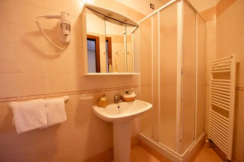 Une salle de bain claire avec douche et lavabo.