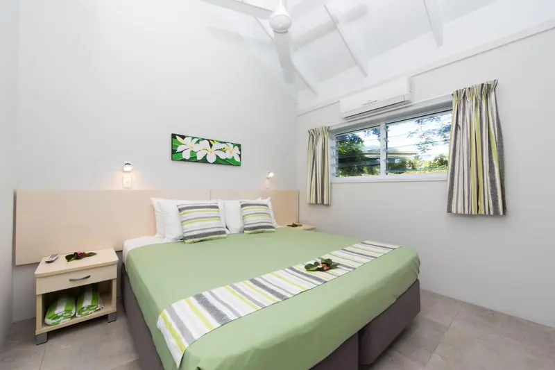 Une chambre lumineuse avec un lit double et une décoration sobre.