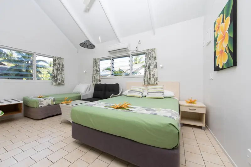 Chambre lumineuse avec deux lits et une décoration florale.