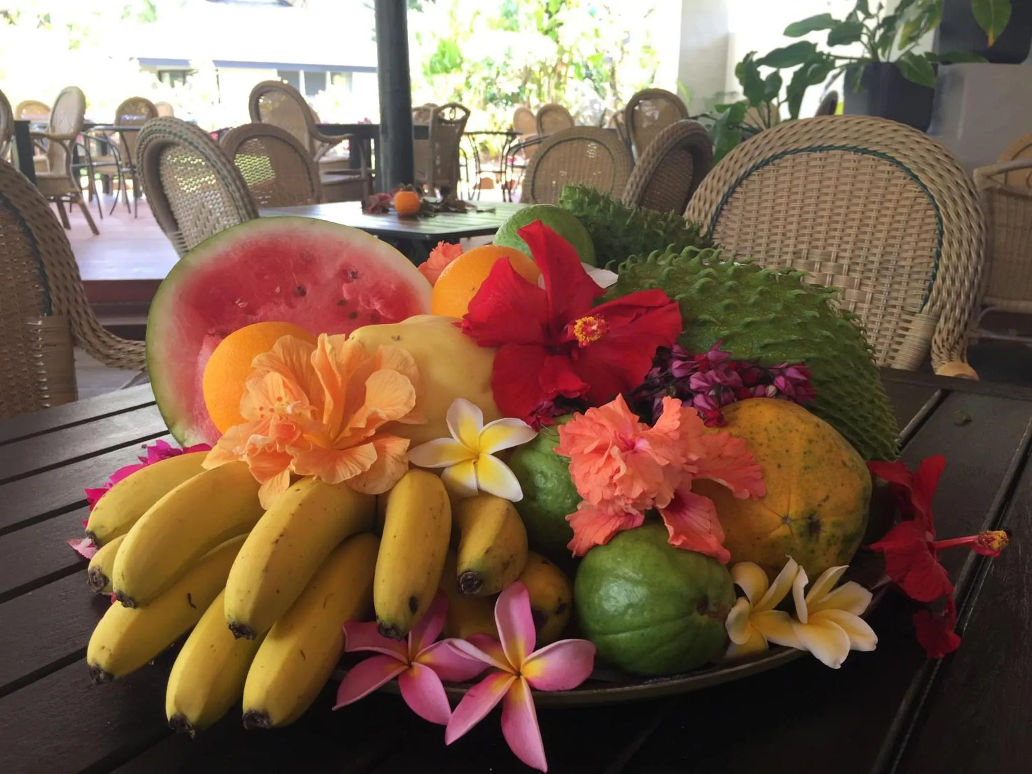 Une table garnie de fruits frais et de fleurs exotiques.