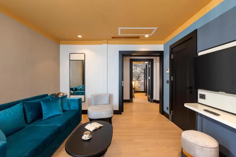 Un salon moderne avec un canapé bleu turquoise et une table basse.