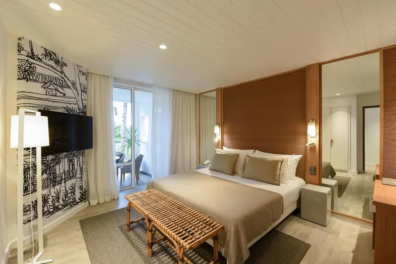 Une chambre lumineuse avec un grand lit et un accès à une terrasse.
