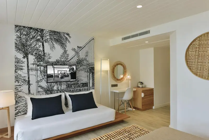 Une chambre lumineuse avec un grand lit et un bureau.