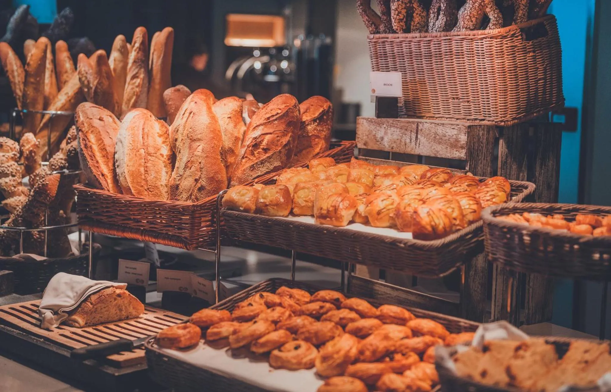 Présentation de pains et viennoiseries variés sur un buffet.