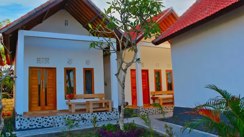Façade d'une maison blanche avec des détails en bois et une petite terrasse.