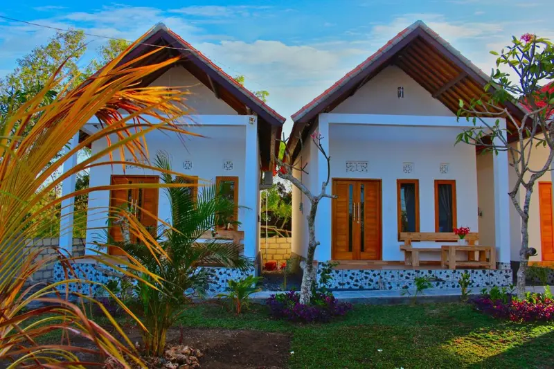 Deux bungalows aux toits de chaume se dressent au milieu d'une végétation luxuriante.