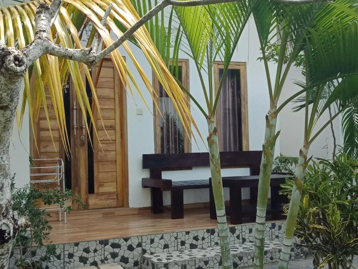 Terrasse en bois avec mobilier devant une porte sombre.