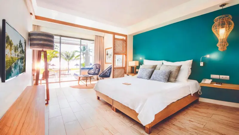 Une chambre lumineuse avec un grand lit et une vue sur la mer.