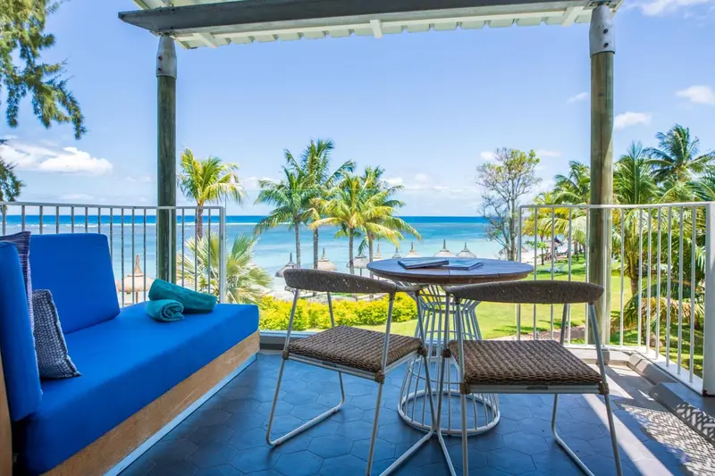 Terrasse avec salon et vue sur la mer et la végétation.