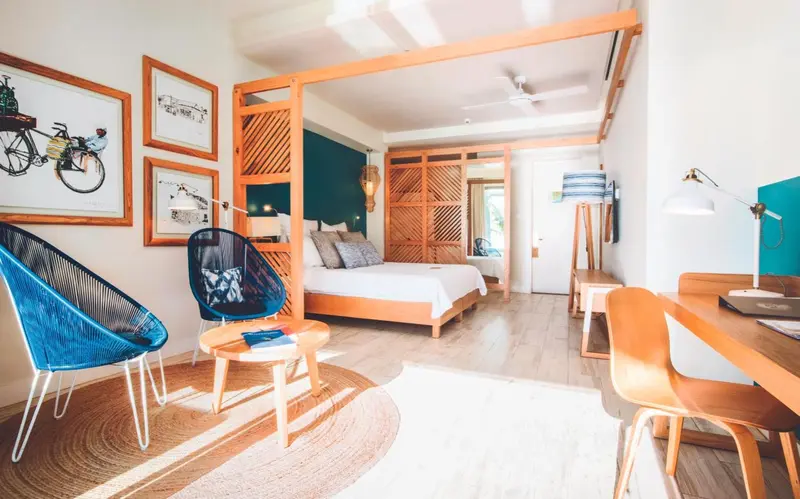 Une chambre lumineuse avec un lit à baldaquin et un coin salon.