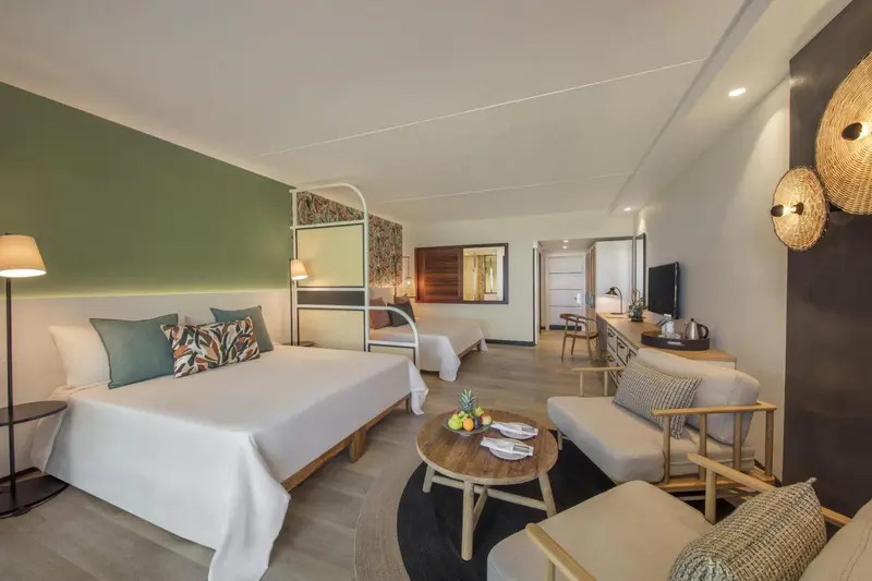 Une chambre lumineuse avec un grand lit et un coin salon.
