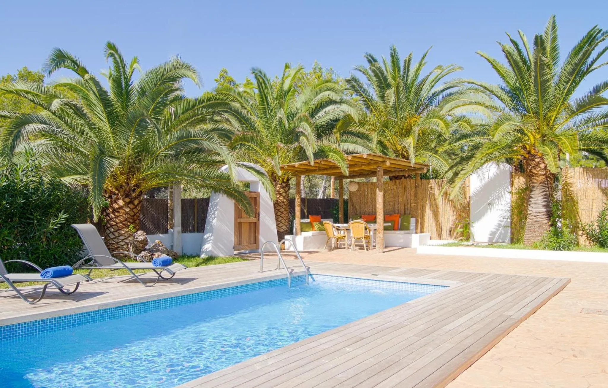 Terrasse avec transats et piscine ensoleillée.