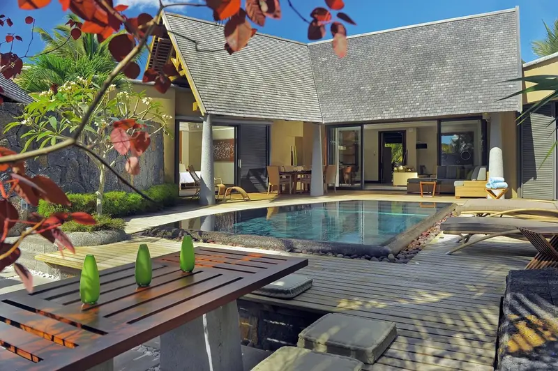 Une piscine rectangulaire bordée d'une terrasse en bois et de mobilier de jardin.
