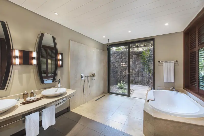 Une salle de bain lumineuse avec baignoire et douche à l'italienne.
