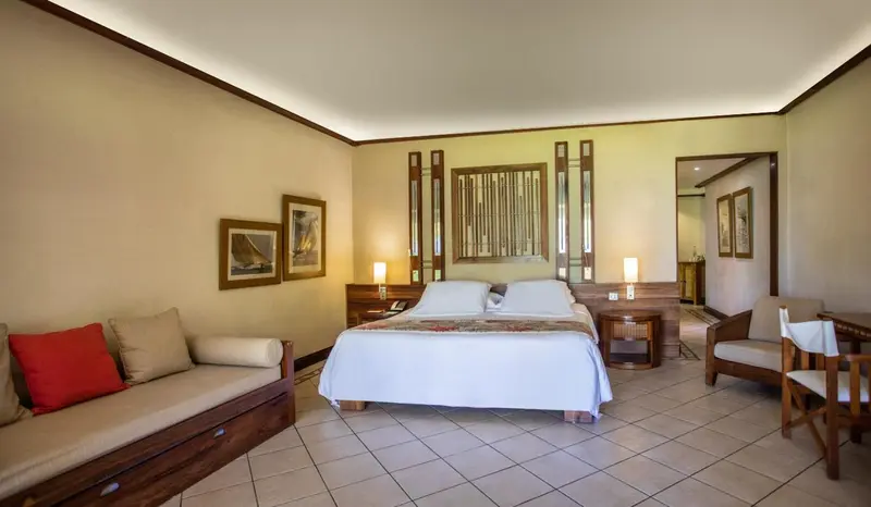 Une chambre lumineuse avec un lit double et un canapé.