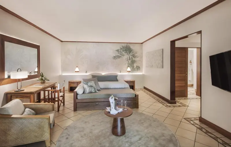 Espace de vie intérieur lumineux avec canapé, fauteuil et table basse.