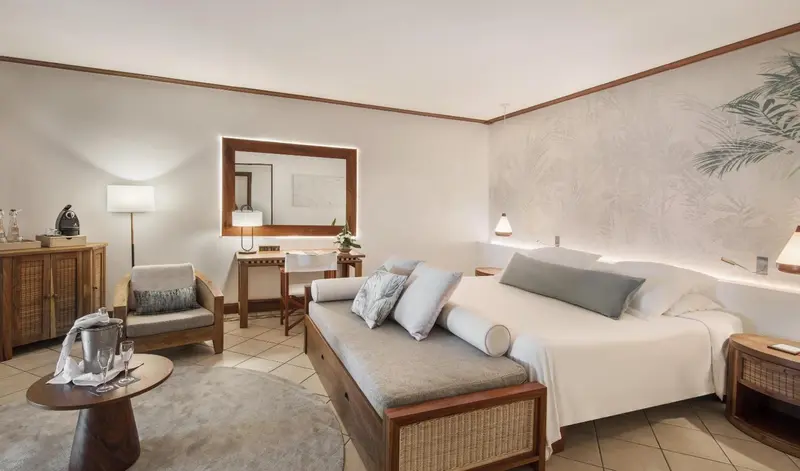 Une chambre lumineuse avec un lit et un coin salon.