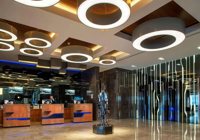 Hall d'accueil moderne avec comptoir d'enregistrement et éclairage design.