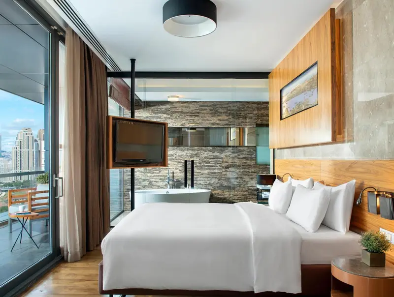 Chambre moderne avec un grand lit et une baignoire intégrée.