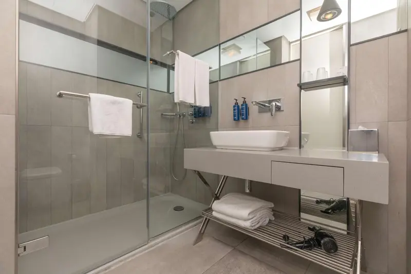 Une salle de bain moderne avec douche à l'italienne et vasque.