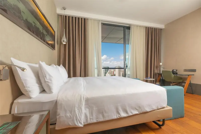 Une chambre lumineuse avec un grand lit et une vue sur la mer.