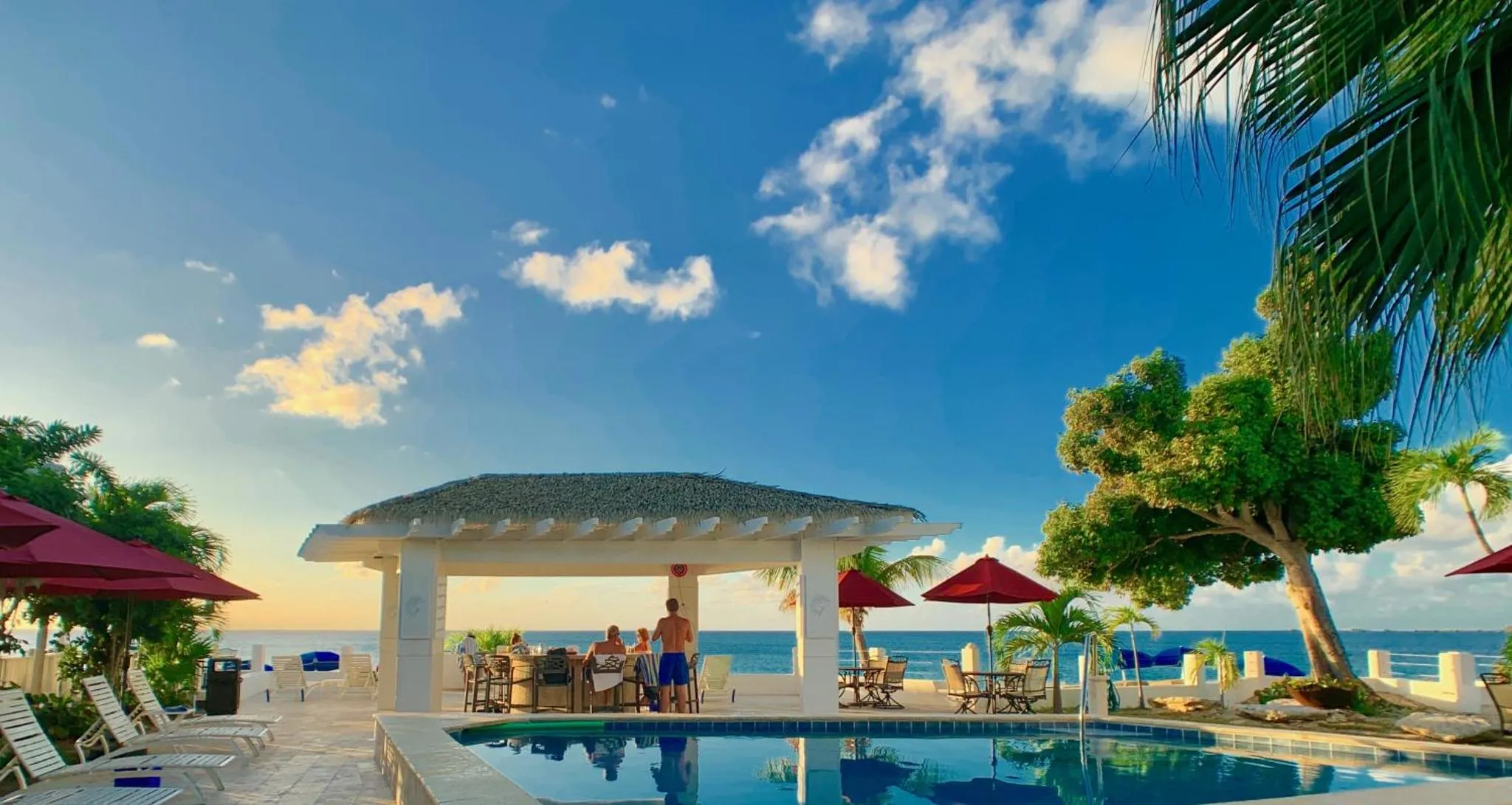 Terrasse avec piscine et mobilier de détente en bord de mer.