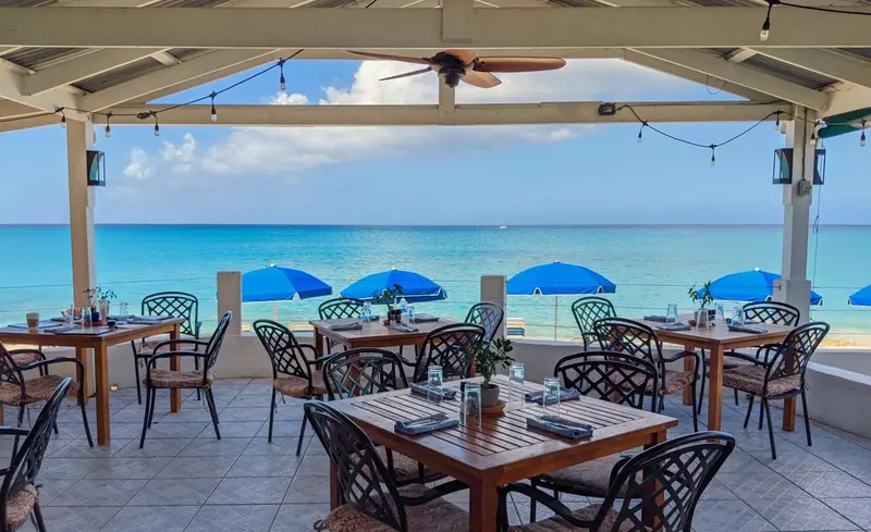 Tables de restaurant en plein air avec vue sur la mer.