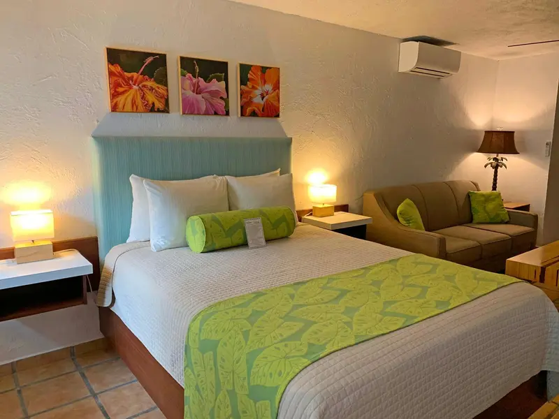 Une chambre lumineuse avec un grand lit et un coin salon.