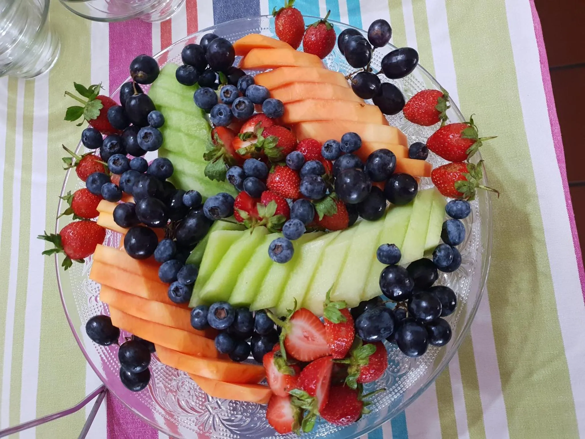 Une assiette de fruits frais est présentée sur une table.