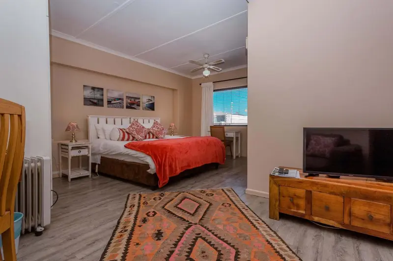 Une chambre lumineuse avec un grand lit et une décoration colorée.