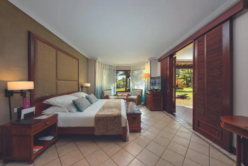 Une chambre lumineuse avec un grand lit et un accès à une terrasse.