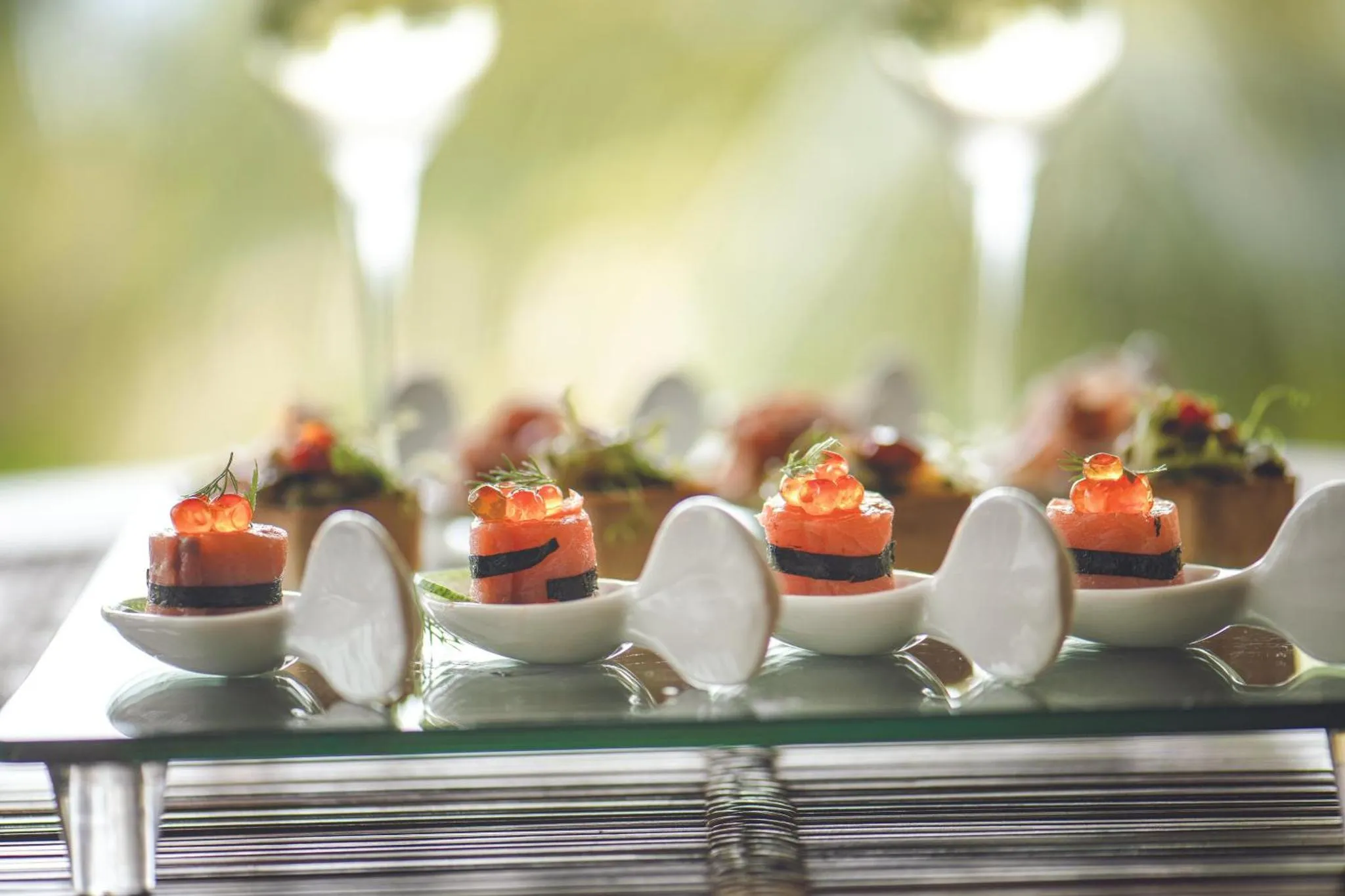 Présentation de canapés raffinés sur un plateau noir brillant.
