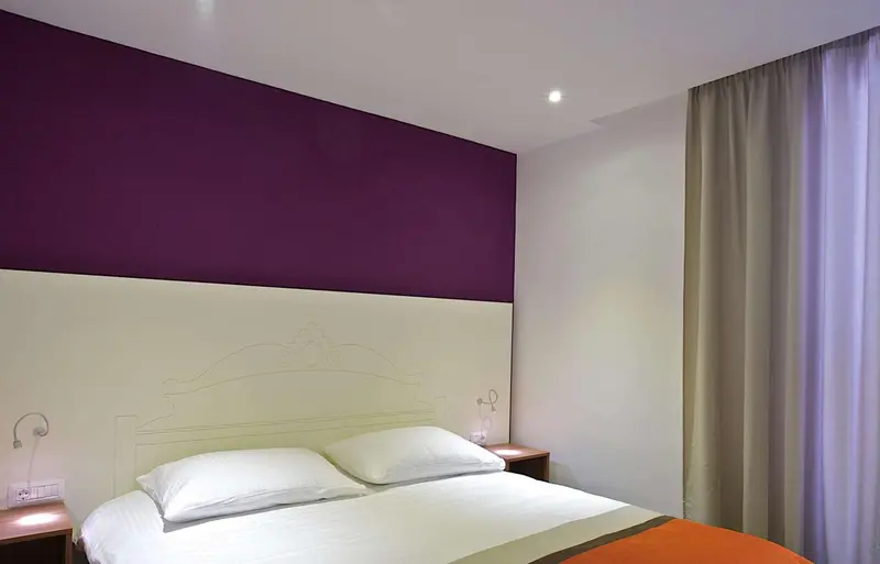 Une chambre avec un lit double et un mur bicolore.