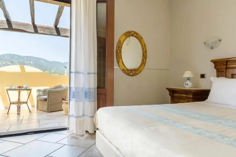 Chambre lumineuse avec un lit soigné et une vue sur les montagnes.
