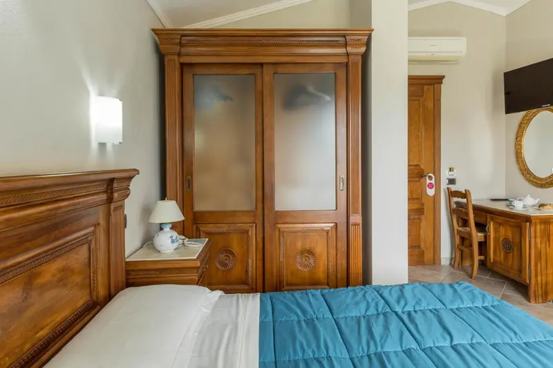 Une chambre d'hôtel avec un grand lit et un placard en bois.