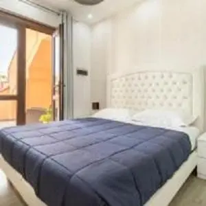 Une chambre lumineuse avec un grand lit recouvert d'une couverture bleue.