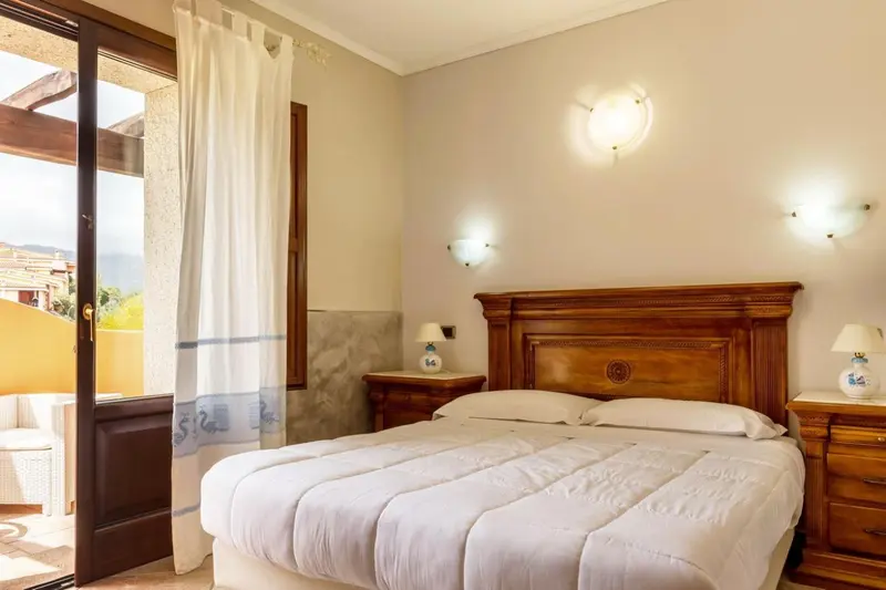 Une chambre lumineuse avec un grand lit et un accès à une terrasse.
