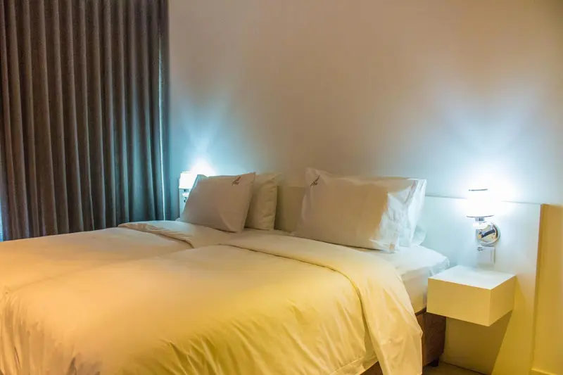Un lit double avec des oreillers blancs dans une chambre lumineuse.